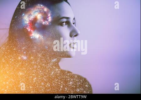 Double multiply exposure abstract portrait of a dreamy cute young woman face with galaxy universe space inside head. Human spirit, astronomy, life zen Stock Photo