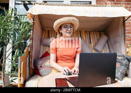 Portrait of mature woman working on laptop on terrace Stock Photo