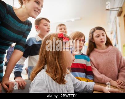 Children learning on a computer with a teacher Stock Photo