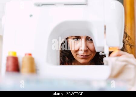 Close-up of focused woman sewing at home Stock Photo