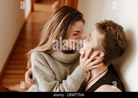 Happy young couple sitting on the floor at home Stock Photo