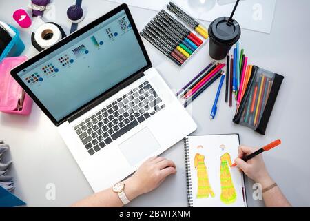 Seamstress using laptop and designing a dress, view from above Stock Photo