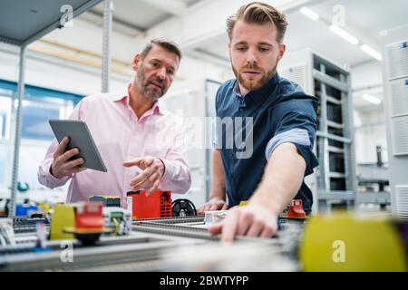 Two men with tablet having a work meeting in a factory Stock Photo