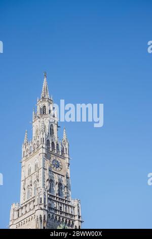 Germany, Bavaria, Munich, Low angle view of New Town Hall clock tower standing against clear blue sky Stock Photo