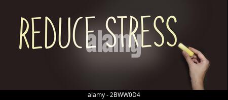 Reduce Stress Written in yellow chalk on a blackboard. No stress and relax mental health healthcare concept Stock Photo