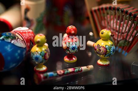 Beautiful vintage colourful wooden dymkovo dolls at market. Dymkovo dolls is folks cultural symbol of Russia. With selective focus on one doll Stock Photo