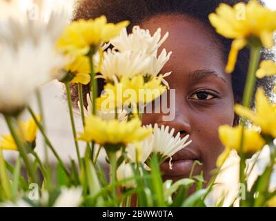 Woman hiding behind flowers Stock Photo
