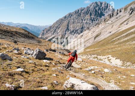 Man riding on mountainbike, Munestertal Valley, Grisons, Switzerland Stock Photo