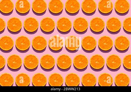 Pattern of orange slices against pink background Stock Photo