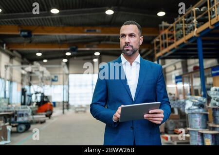 Businessman using tablet in a factory Stock Photo