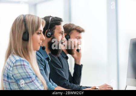 Line of call centre employees working on computers Stock Photo