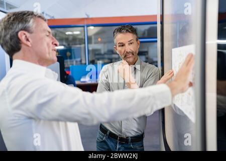 Businessmen in factory, having a meeting, discussing plans Stock Photo