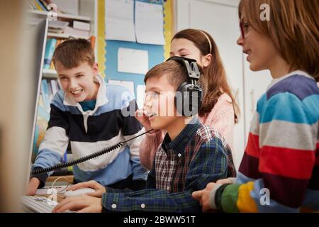 Children playing on a computer in classroom Stock Photo