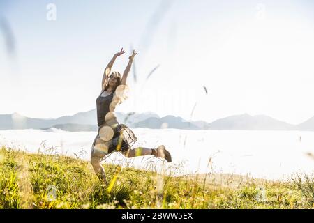 Carefree woman on a meadow in the mountains, Achenkirch, Austria Stock Photo