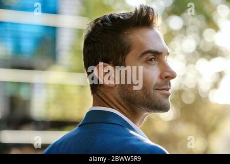 Young businessman looking around while standing in the city Stock Photo