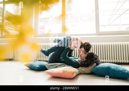 Happy mother playing with daughter on the floor Stock Photo