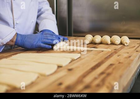 A hand of a chef roll french bread croissant Stock Photo