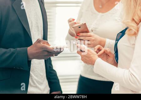 young business people reading messages on their smartphones Stock Photo