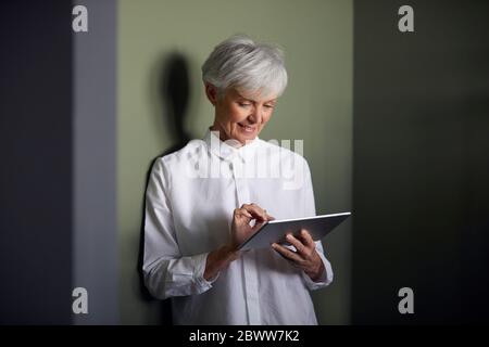 Portrait of senior businesswoman using digital tablet Stock Photo