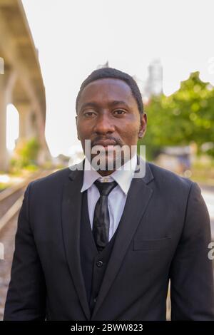 Handsome bearded African businessman at the train station outdoors Stock Photo