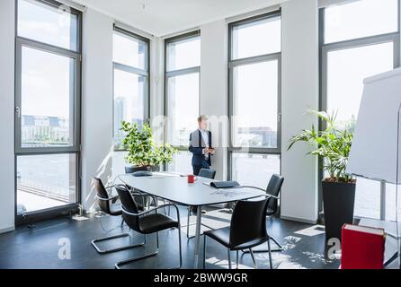 Businessman standing at thw window in office Stock Photo