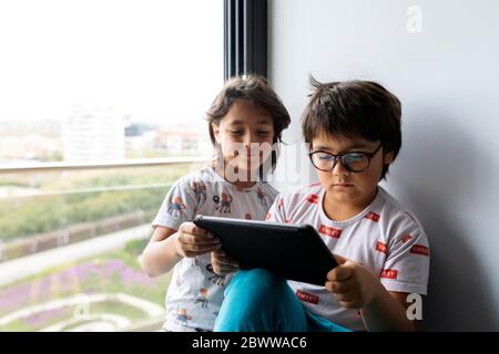 Portrait of two brothers at home using digital tablet Stock Photo
