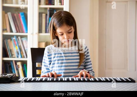 Girl playing roll piano at home Stock Photo