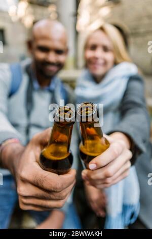 Couple toasting with beer bottles, Barcelona, Spain Stock Photo