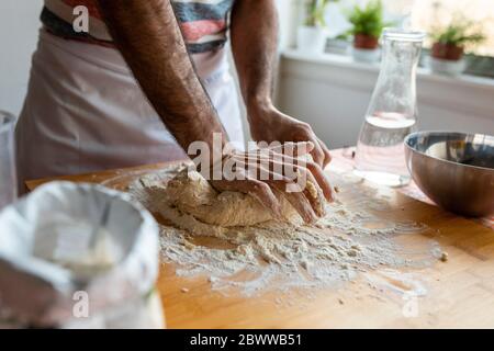 Crop view of man kneading dough