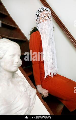 Young woman wearing crocheted white headdress with fringes Stock Photo