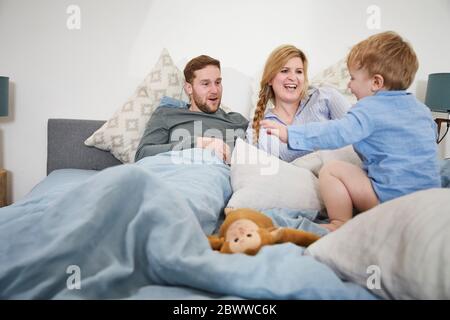 Family relaxing and jumping on bed Stock Photo