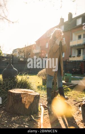 Smiling young woman in garden in sunshine Stock Photo