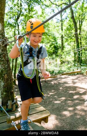 Boy on a high rope course in forest Stock Photo