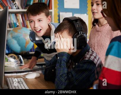 Children playing on a computer in classroom Stock Photo