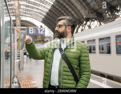 Man checking the timetable at the train station Stock Photo