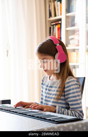 Girl playing roll piano at home Stock Photo