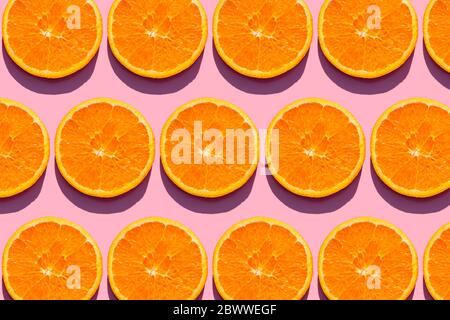 Pattern of orange slices against pink background Stock Photo