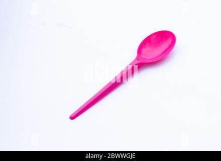 one vibrant pink plastic spoon isolated on white Stock Photo
