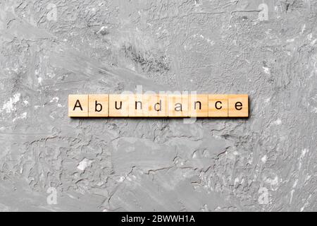 abundance word written on wood block. abundance text on table, concept. Stock Photo