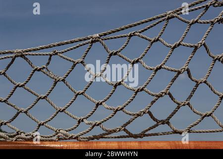 Rope net on a vintage sailing vessel against a blue sky, horizontal aspect Stock Photo