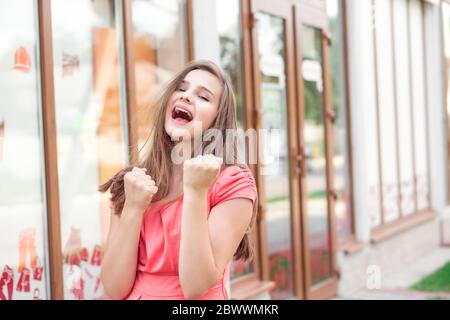 Winner. Young woman smiling looking up pumping fists celebrating freedom success. Positive human emotion face expression feeling life perception peace Stock Photo