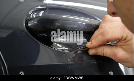 Close up to PPF installation process on a front headlight and hood. PPF is  a Paint Protection Film which protect paint from scratches and stone chips  Stock Photo - Alamy
