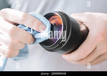 Cleaning the lens glasses from dust with a microfiber cloth Stock Photo