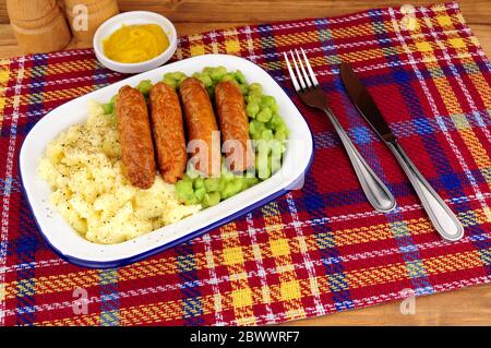 Sausage and mashed potato meal with mushy peas in a metal enamel dish Stock Photo