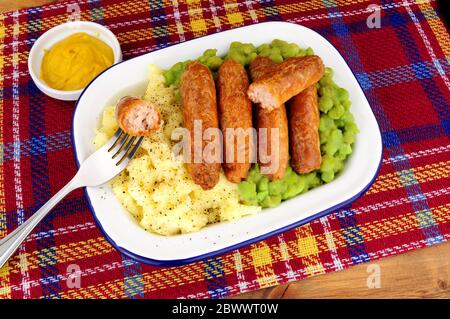 Sausage and mashed potato meal with mushy peas in a metal enamel dish Stock Photo