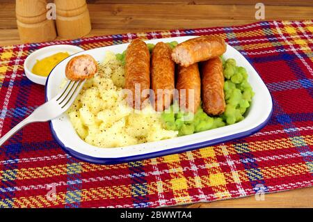 Sausage and mashed potato meal with mushy peas in a metal enamel dish Stock Photo