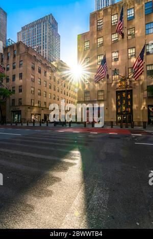 The sun sets in to among the high-rise Rockefeller Center buildings during the Quarantine for COVID-19 at New York NY USA on Memorial Day May 25 2020. Stock Photo