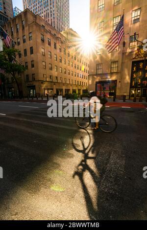 The sun sets in to among the high-rise Rockefeller Center buildings during the Quarantine for COVID-19 at New York NY USA on Memorial Day May 25 2020. Stock Photo