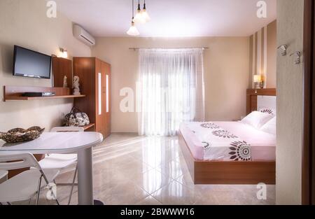 Romantic style interior of simple modern design bedroom with wooden furniture in white and beige apartment hotel room Stock Photo