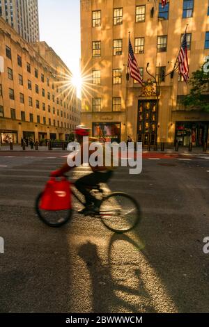 The sun sets in to among the high-rise Rockefeller Center buildings during the Quarantine for COVID-19 at New York NY USA on Memorial Day May 25 2020. Stock Photo